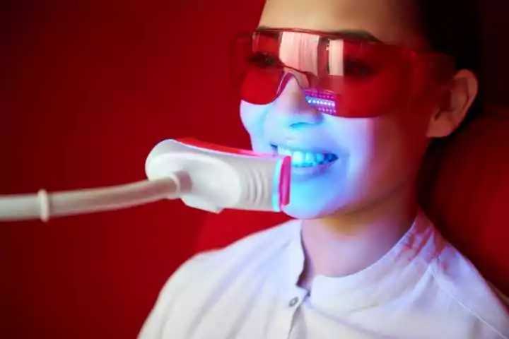 mulher utilizando clareamento dentário