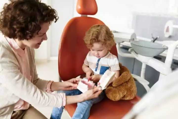 criança sentada na cadeira do dentista