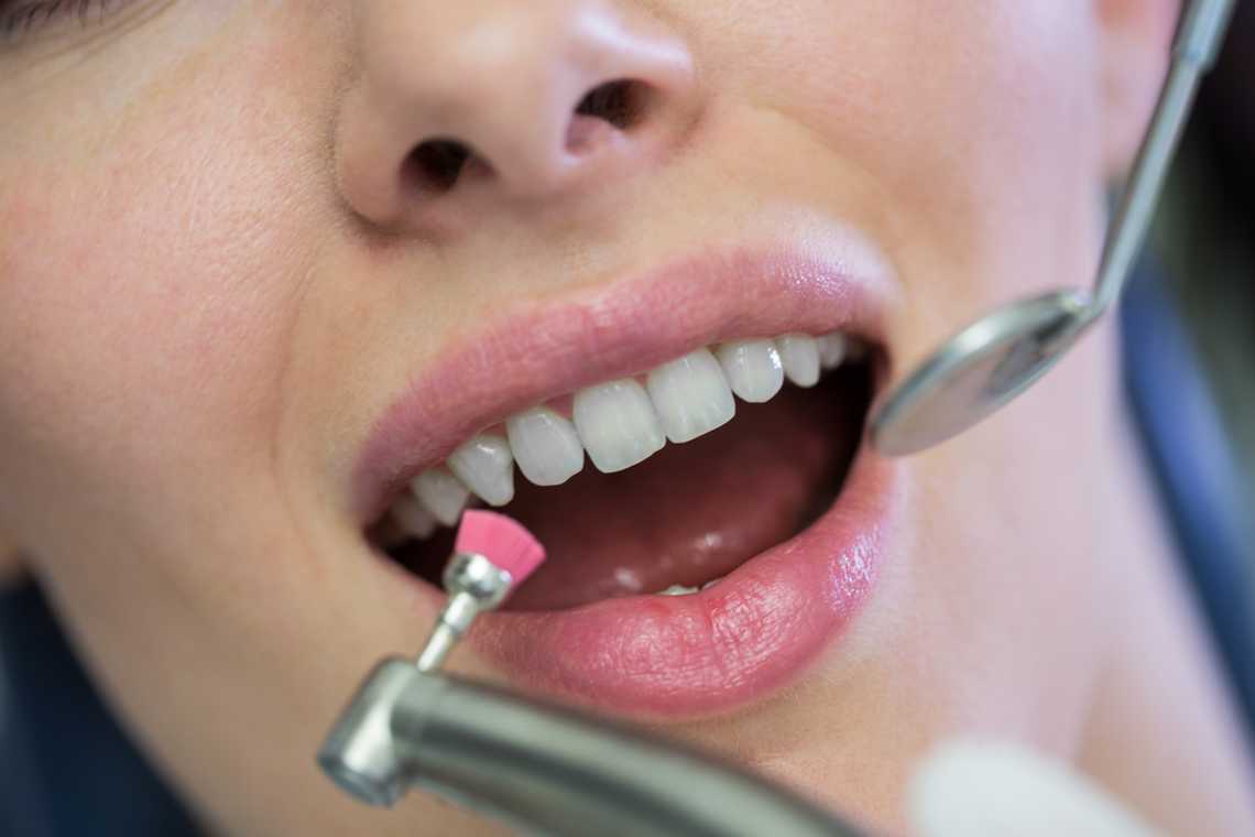 dentista examinar uma paciente do sexo feminino com ferramentas